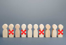 Wooden human figures in a row with red X marks on some