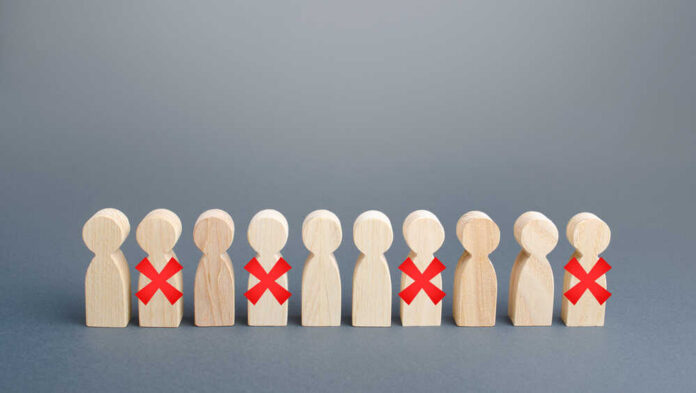 Wooden human figures in a row with red X marks on some
