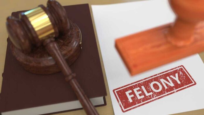 Judge's gavel on book beside paper stamped felony