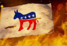 Feds Hit Dem’s Home Torn Democratic flag burning amid flames and embers.