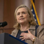 Hillary Clinton speaking at a podium with a microphone