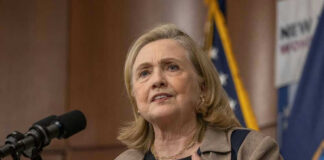 Hillary Clinton speaking at a podium with a microphone