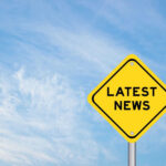 Yellow sign with text Latest News on sky background