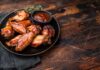 Chicken wings with barbecue sauce on a black plate