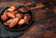 Sweet-And-Sour Wings Spark Outrage Online Chicken wings with barbecue sauce on a black plate