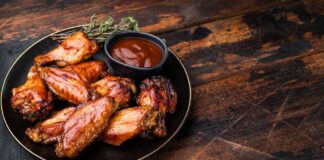 Chicken wings with barbecue sauce on a black plate