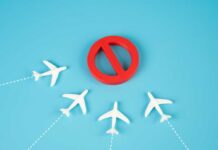 Chaos Turns Nation Into No-Fly Trap A red prohibition sign surrounded by white airplane models on a blue background