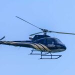 A helicopter flying against a clear blue sky