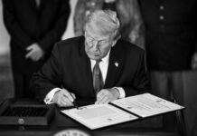 Brutal Poll Hammers Trump man in suit signs a document at a desk