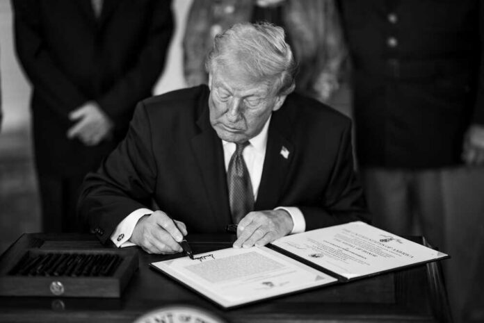 President,Donald,J.,Trump,Greets,Guests,And,Family,Members,Of man in suit signs a document at a desk