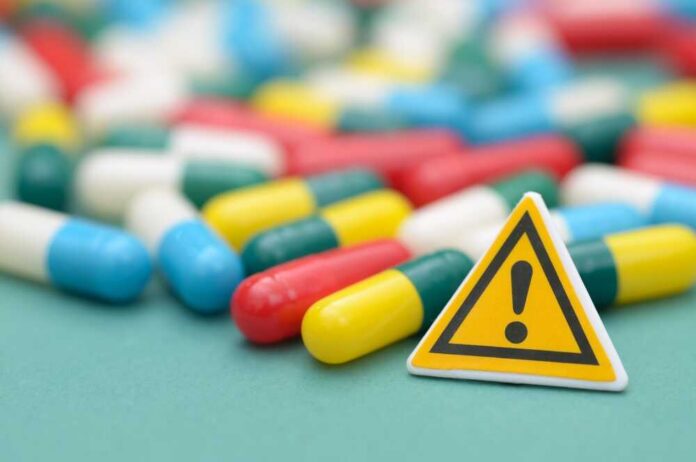 Danger,Of,Drug,Overdose,And,Medication,Safety Capsules and a yellow warning sign