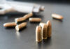 Superstar’s Home Riddled By Bullets – Nursery Hit Close-up of bullets on a dark surface with a handgun in the background